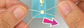 Thread being threaded through a bead